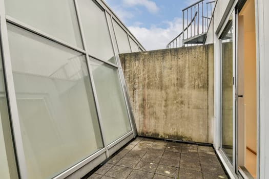 An outdoor space featuring sleek, modern architecture with minimalist design elements, including textured walls and expansive glass windows.