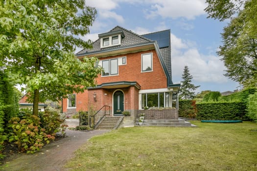 A charming modern family home features large windows, a well-maintained garden, and lush greenery. Perfect blend of comfort and contemporary design in a serene setting.