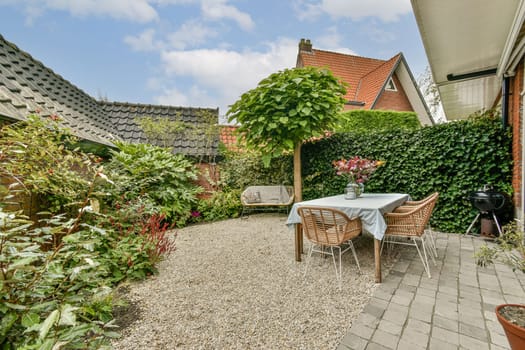 A serene garden patio featuring a cozy seating area, lush green plants, and a delightful arrangement of flowers, perfect for relaxation and outdoor gatherings.