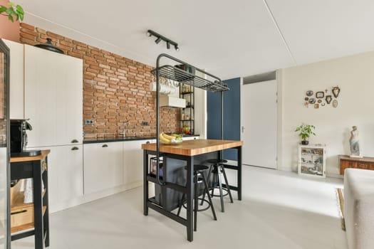 A stylish modern kitchen featuring an open layout with a mix of brick walls and sleek furnishings, perfect for contemporary living and entertaining.