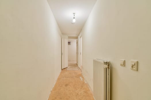 A spacious modern hallway featuring white walls and a simple design. The area is well-lit, with a minimalistic aesthetic that emphasizes simplicity and openness.