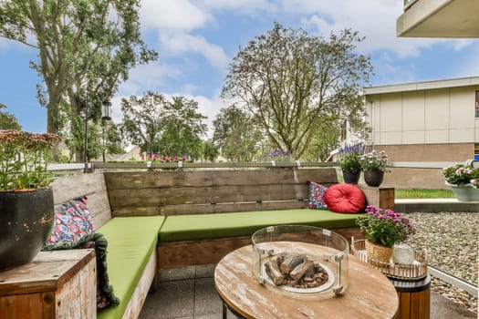 A beautifully designed outdoor lounge featuring comfortable seating, vibrant cushions, and lush trees, creating a tranquil space for relaxation.