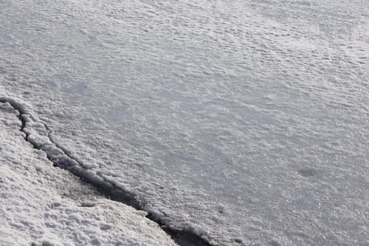 The surface of the river is covered with ice and snow.