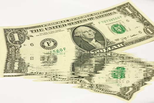 Creative conceptual image of US dollar bills partially submerged in water with a water reflection effect. Symbolizes financial crisis, liquidity problems, or a fluctuating economy. Ideal for articles or graphics related to money, finance, economics, or global markets.