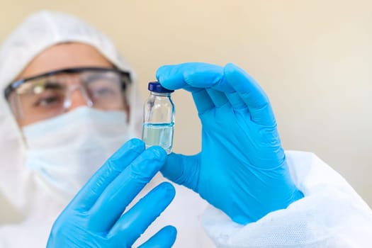 Medicine in a bottle in the hands of a doctor. Selective focus. vaccine