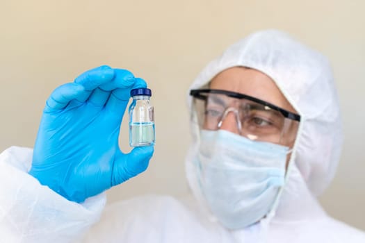 Medicine in a bottle in the hands of a doctor. Selective focus. vaccine