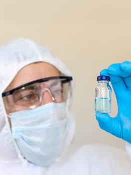 Medicine in a bottle in the hands of a doctor. Selective focus. vaccine