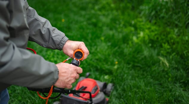 A person carefully inspects an electric lawn mower, adjusting its settings while surrounded by lush, vibrant green grass. This moment reflects spring's essence and the commitment to yard upkeep.