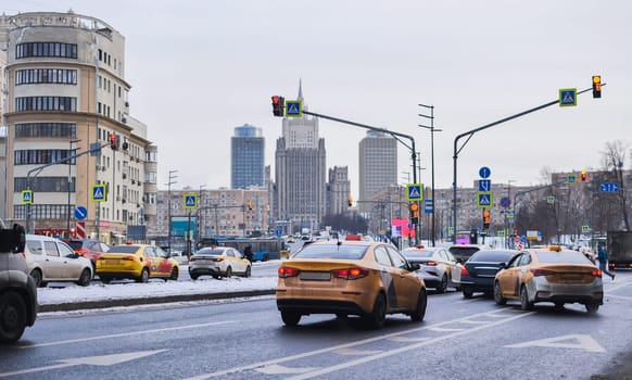 Yellow taxis driving on a winter day in Moscow with the Ministry of Foreign Affairs of Russia building in the background