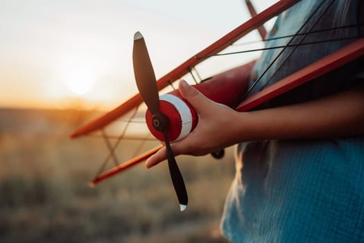 5 years old preschool child boy plays with craft wooden retro styled airplane toy, discovering future profession interest, dreamer kid flying, traveling. High quality photo