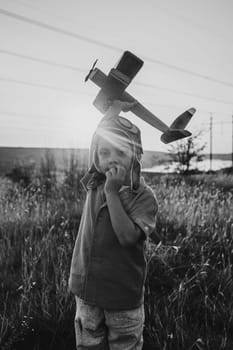 Smiling curious 5 years old preschool child boy plays with craft wooden retro styled airplane toy, discovering future profession interest, dreamer kid flying, traveling. High quality photo