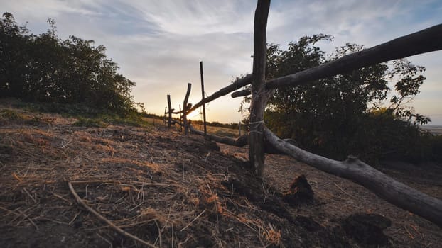 Rustic wooden fence dividing fields in the Crimean countryside at sunset, near the town of Belogorsk