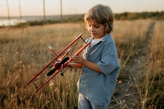 Smiling curious 5 years old preschool child boy plays with craft wooden retro styled airplane toy, discovering future profession interest, dreamer kid flying, traveling. High quality photo