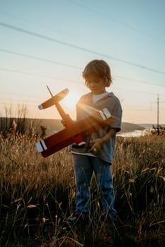Smiling curious 5 years old preschool child boy plays with craft wooden retro styled airplane toy, discovering future profession interest, dreamer kid flying, traveling. High quality photo