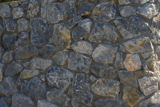 Rugged stones interlock to form a sturdy wall, displaying a rich tapestry of colors and textures.