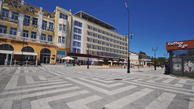 Tourists walking in nakhimov square in sevastopol, crimea, russia, with colorful buildings and geometric pavement
