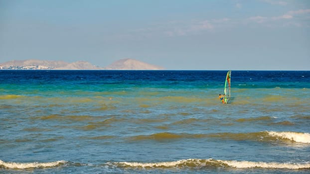 Windsurfer surfing in Koktebel bay with view of White Rock mountain in Crimea