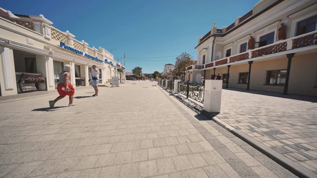 People walking on a paved street in Gurzuf, Crimea, Russia, during summer vacation