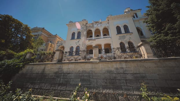 Crumbling facade of a historic mansion in crimea, showcasing its weathered beauty against a backdrop of clear blue skies, overlooking the black sea