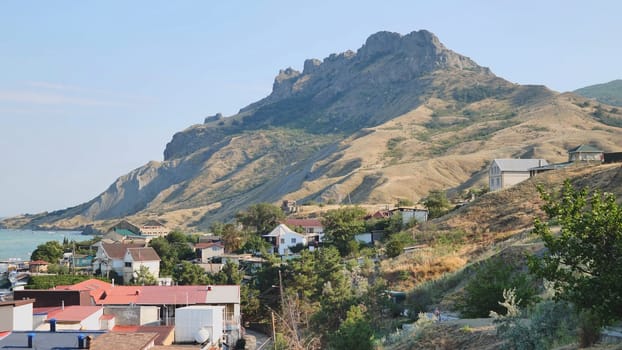 Houses climbing the hills of Koktebel, Crimea, with the extinct volcano Kara Dag dominating the landscape