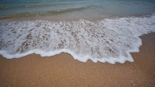 Gentle waves washing sandy shore of crimean coastline, peaceful black sea landscape with soft, rolling water
