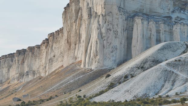 White rock Ak-Kaya in Belogorsk, Crimea, under cloudy sky is towering above green valley