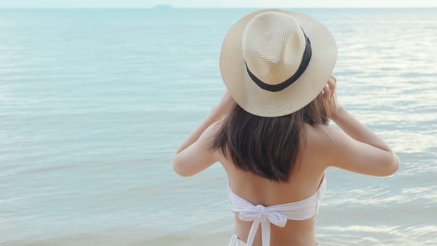 Beautiful Asian woman holding rubber ring running on the beach, Happy female in bikini having fun on tropical beach vacation getaway travel holiday destination, relaxing feeling free in summer holiday