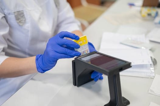 A narcologist tests urine for drugs using an electronic device