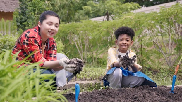 Happy children group girl and boy of diverse learning environment for plants vegetable at garden farm they holding black soil on hands, Ecology, agriculture school learning