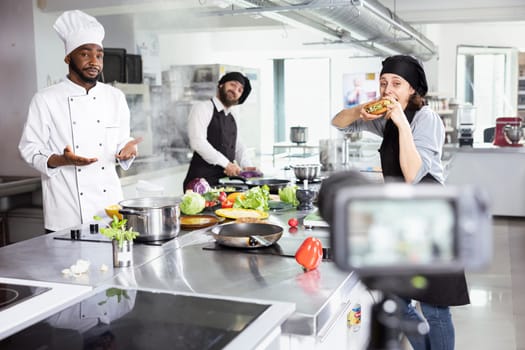 Diverse cooks team recording a fine dining cooking technique on camera, teaching beginners to learn complex meal recipes. Kitchen setup perfect for an engaging online master class.