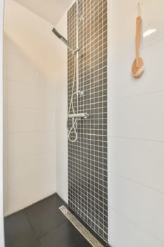 a bathroom with black and white tiles on the walls, along with a shower head in the floor is tiled