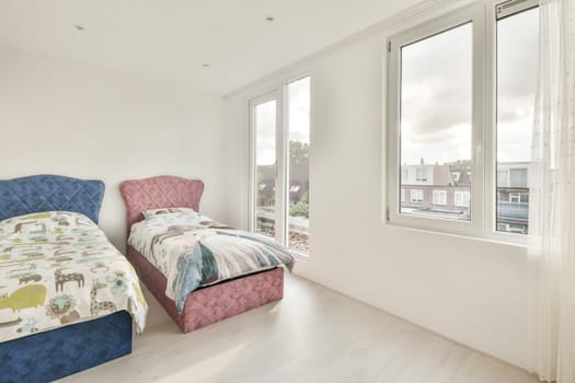 a child's bedroom with white walls and hardwood flooring the room is decorated in pink, blue and green