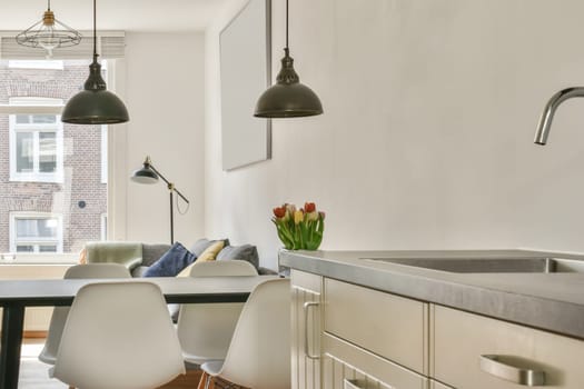 a kitchen and dining area in a modern apartment with white walls, wood flooring and large windows overlooking the city