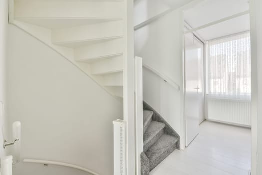 an empty room with white walls and wooden floors, there is a staircase leading to the second floor in this apartment