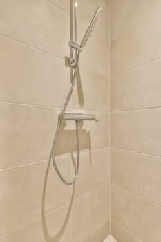 a shower with a hand held shower head and handset on the wall, in a white tiled bathroom background