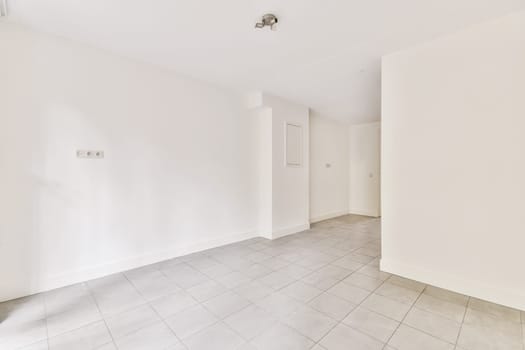 an empty room with tile floor and white walls, there is a door in the corner to the left side