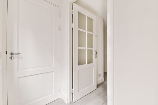 an empty room with two doors and one door opened to reveal the other rooms in the apartment has white walls