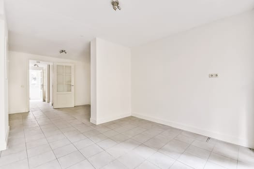 an empty room with tile floor and white walls, there is a door leading to the left side of the room