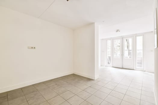 an empty living room with tile flooring and sliding glass door leading to the patio area in this apartment building