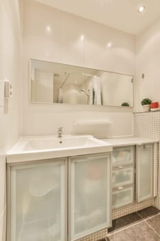 a bathroom with two sinks and a mirror on the wall behind it is a plant in a red vase sitting next to the sink