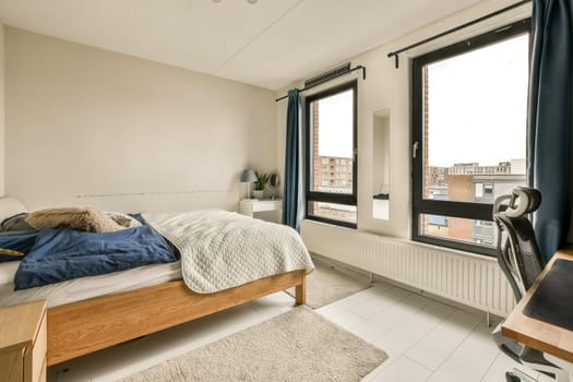 a bedroom with a bed, desk and window looking out onto the cityscapearron com logo on the wall