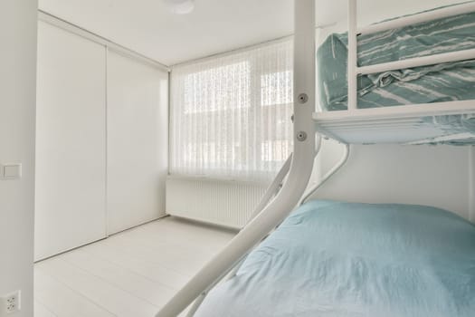 a bedroom with bunks and a bed in the middle part of the room there is a window to the outside