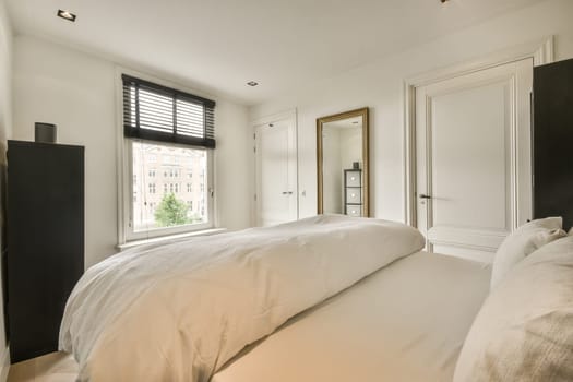a bedroom with white bedding and black shutters on the windows in the room is lit by light from outside