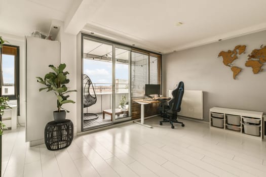 a living room with a desk, chair and large window looking out onto the cityscapearl view