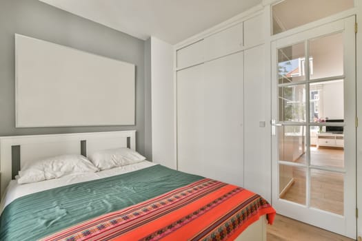 a bedroom with a bed, closets and sliding glass doors leading to the balcony area in an apartment building