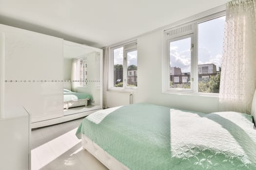 a bedroom with white walls and green bedspremnveses on the bed in front of the window