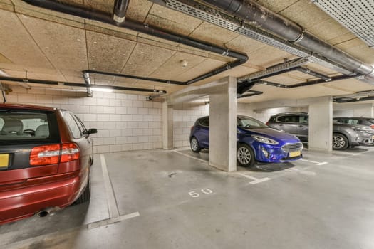 an underground parking area with cars parked in the space and two people standing on either side of each other vehicles