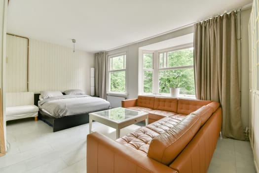 a bedroom with an orange couch and white bed in the room is very spacious, but it's not too