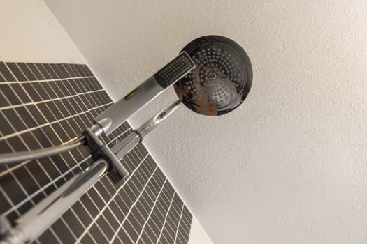 a shower head with thermostaer attached to it's side, in front of a white wall
