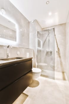a modern bathroom with white marble walls and flooring, along with a walk - in shower on the right side